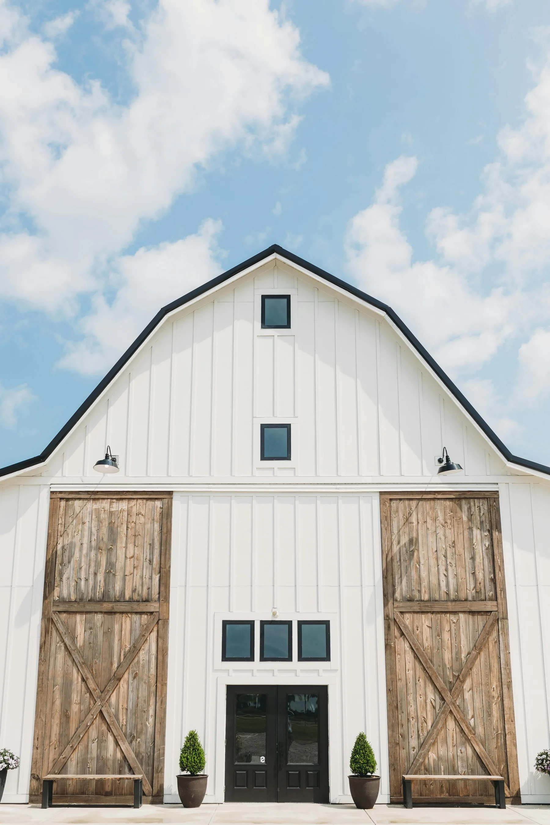 Casa blanca de estilo rural con madera natural y cielo despejado